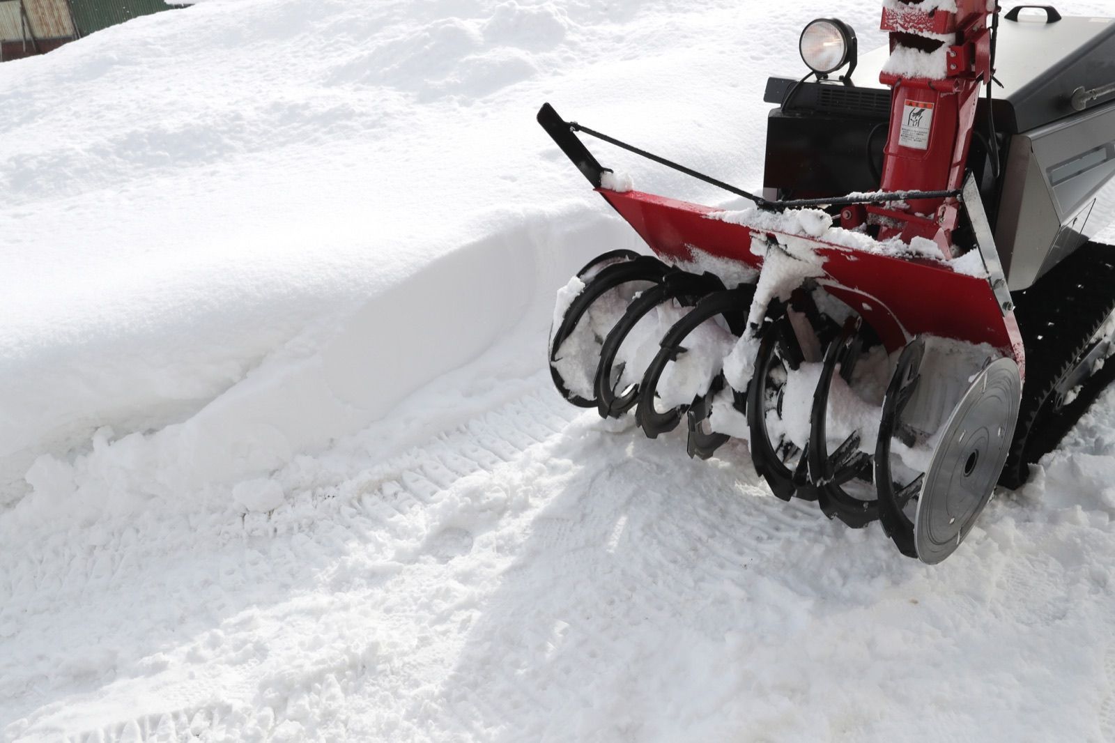 雪の中に置かれた除雪機の回転部（イメージ写真）